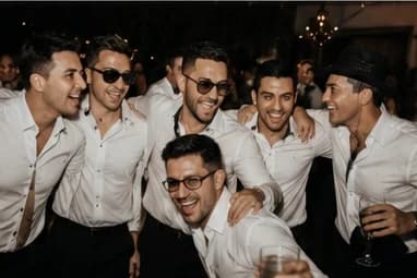 Groupe d’invités en chemise blanche, ambiance de fin de soirée